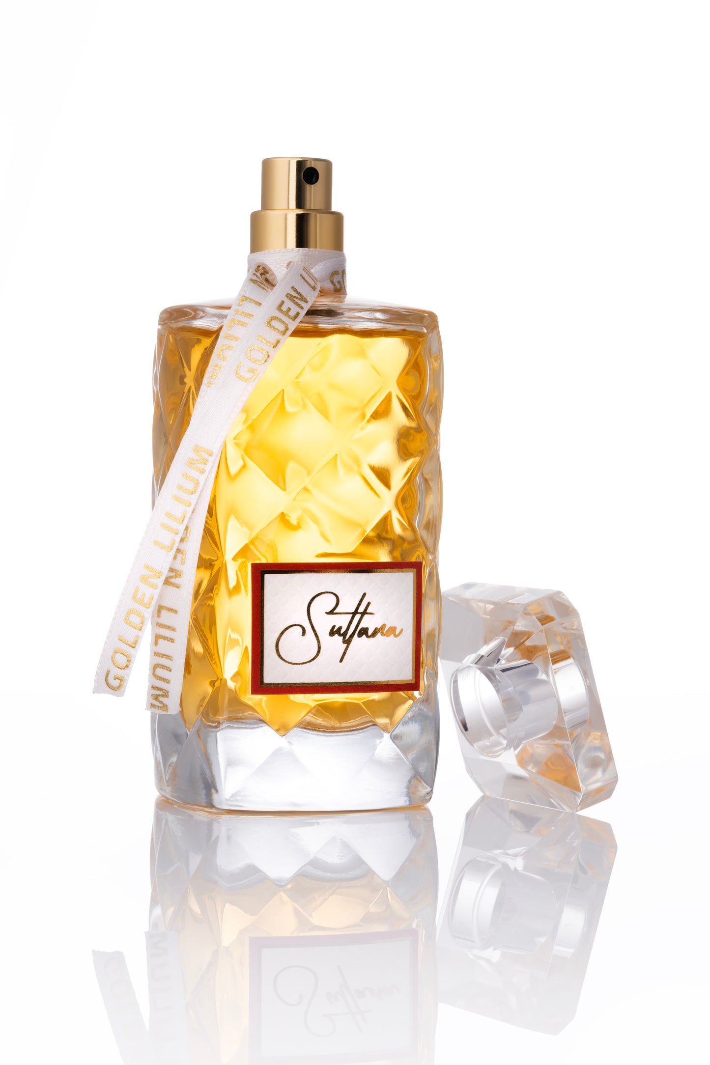 Perfume bottle with gold cap and diamond-patterned glass on a white background