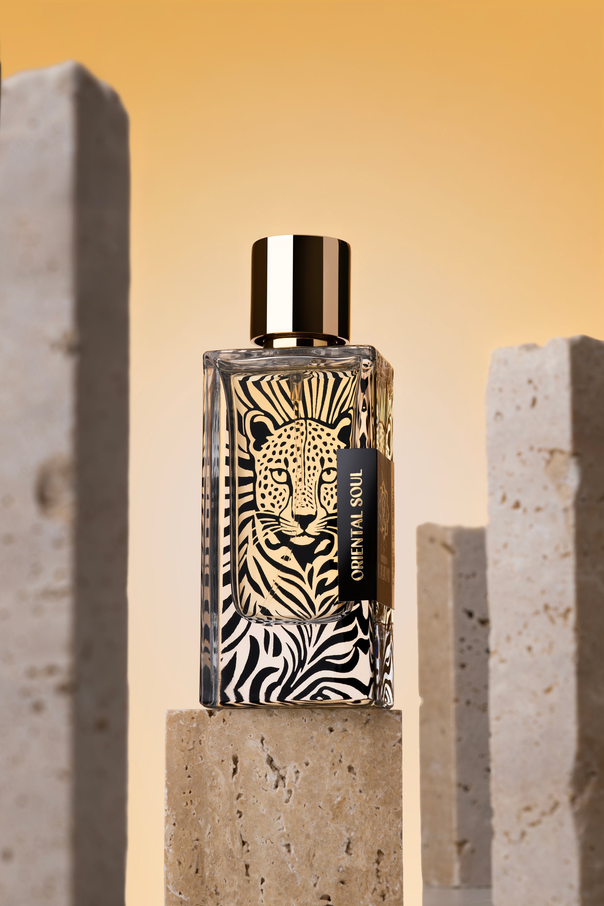 Perfume bottle with zebra pattern and leopard design on a stone surface with a warm background