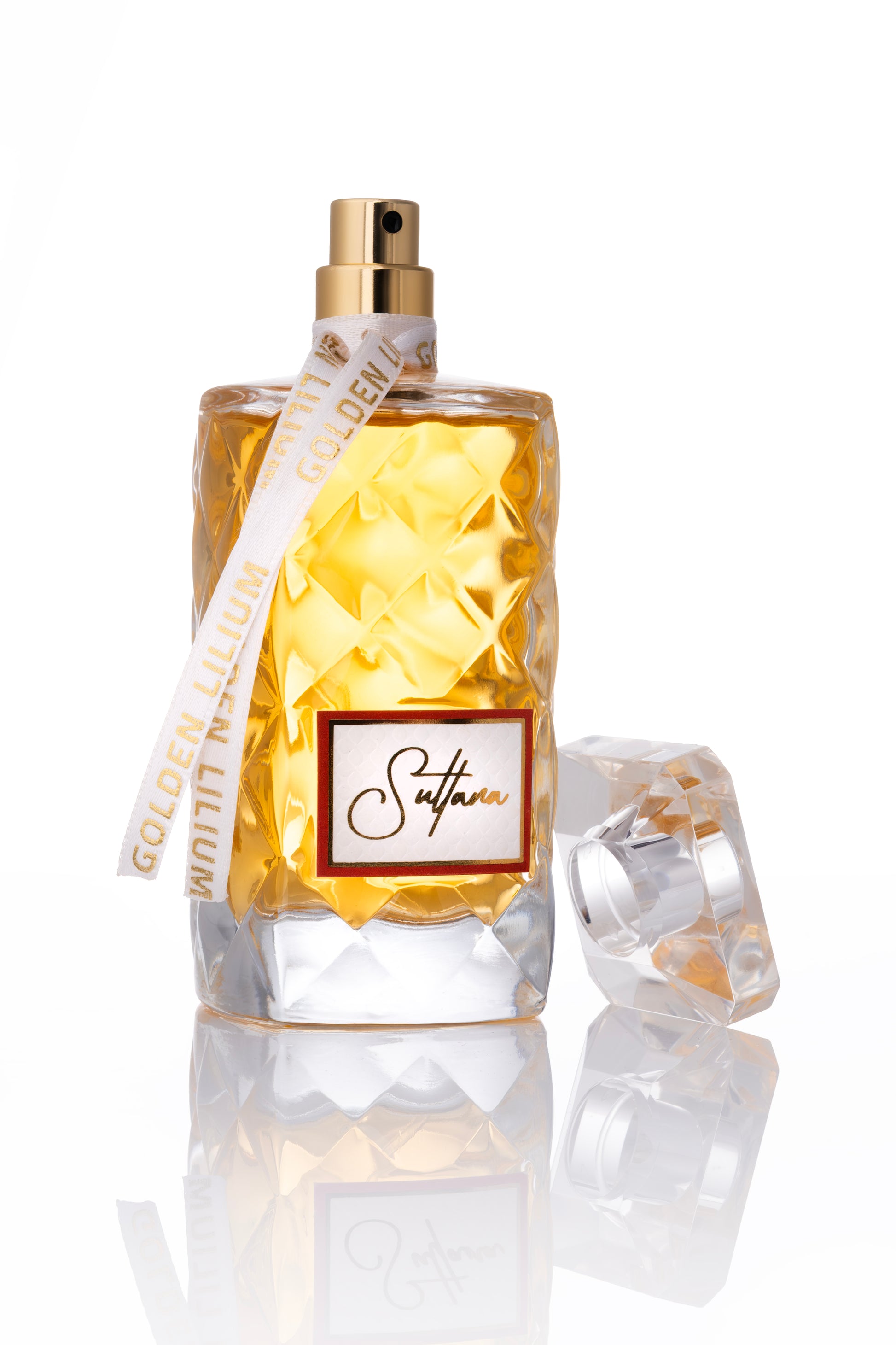 Perfume bottle with gold cap and diamond-patterned glass on a white background